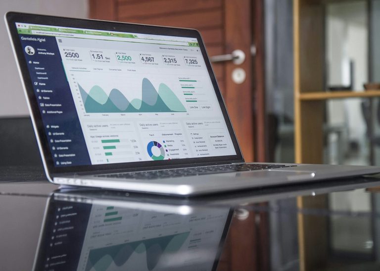 Ordinateur portable posé sur une table en verre affichant des données d'analyse de site web